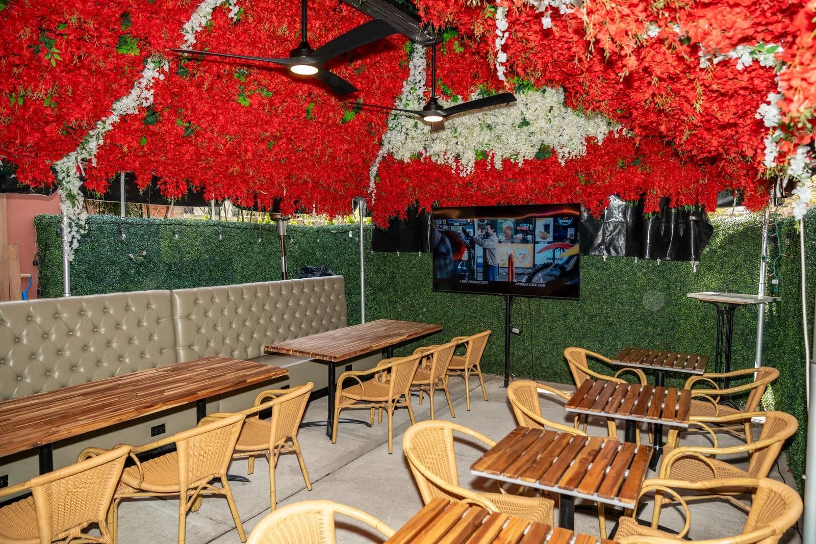 GG’s outdoor space with red overhead foliage and wooden tables