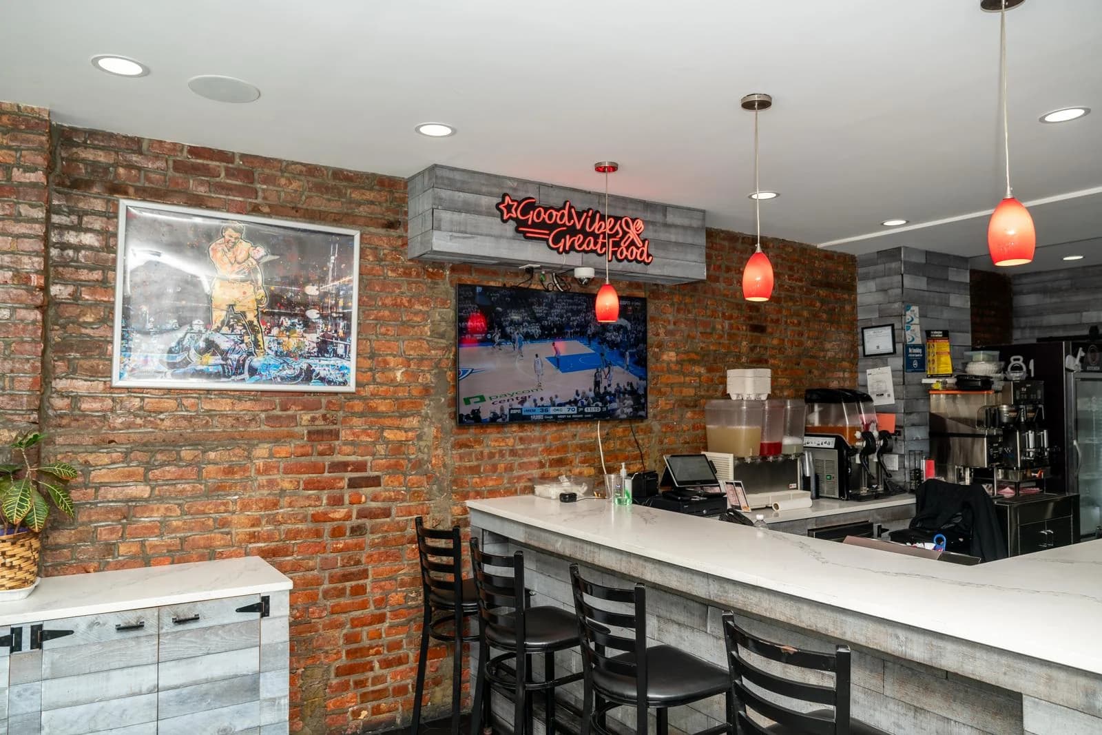 Inside GG’s, with brick walls, counter seating and red pendant lights